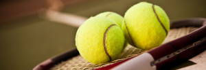 A shot of a tennis racquet and tennis balls on the tennis court